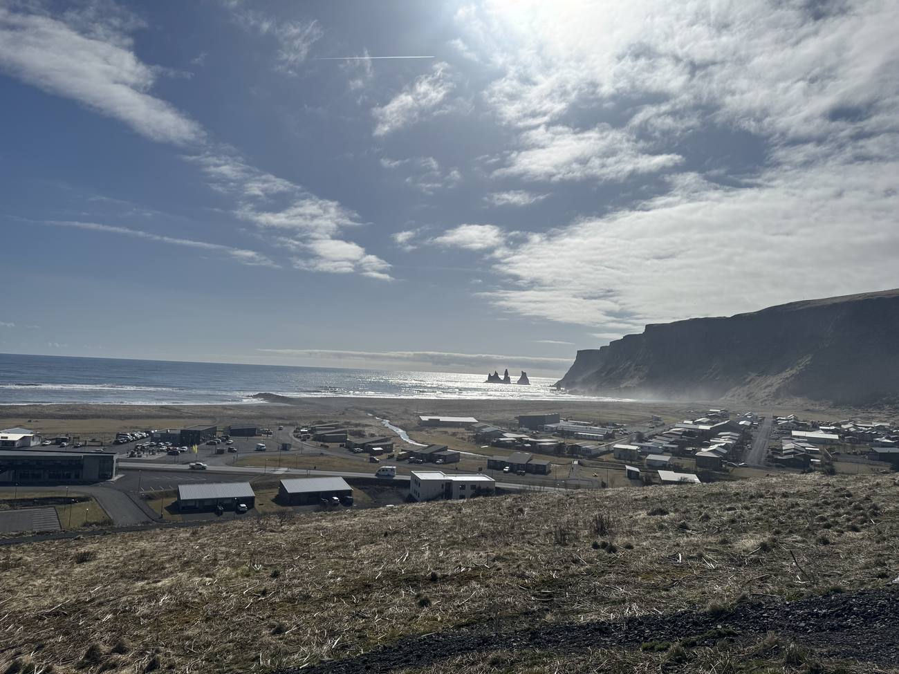 The village of Vik i Myrdal above its black beach, seen from the hillside on a clear day